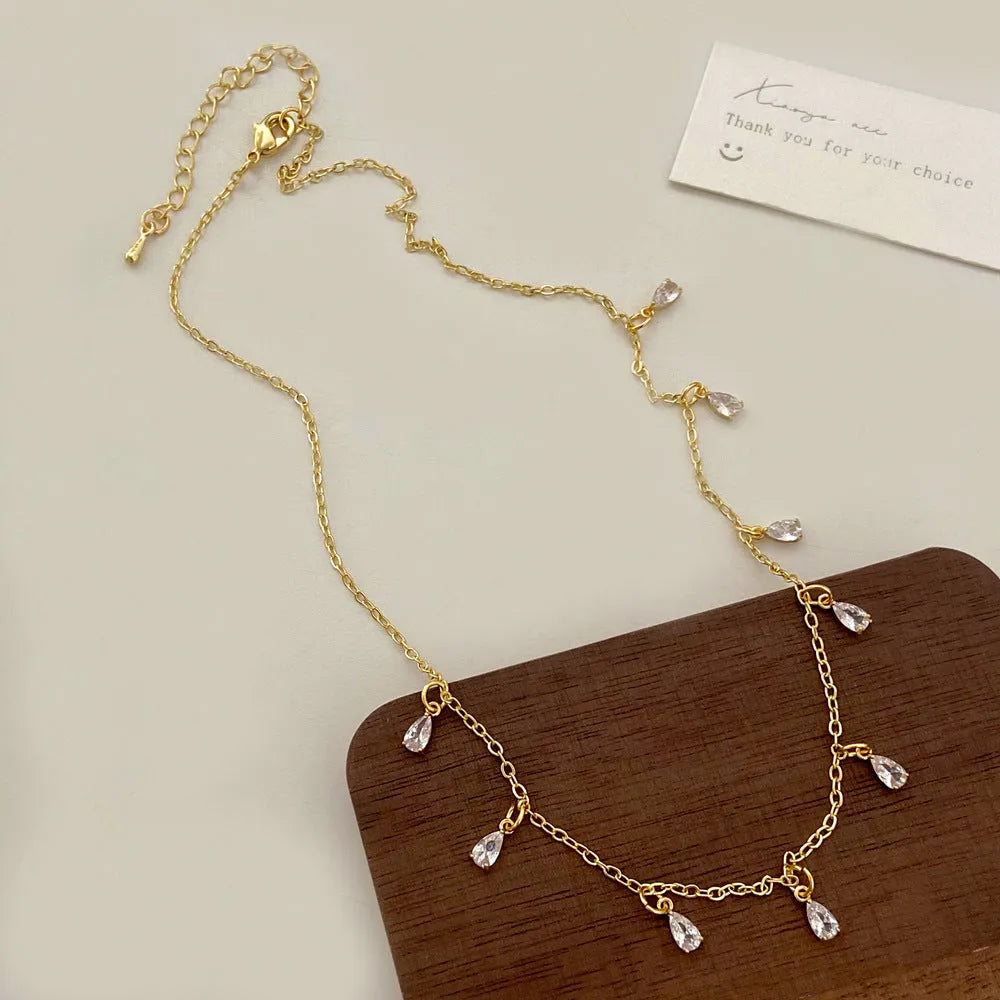 Women's zircon jewellery set with geometric meteor shower necklace, matching earrings, and anklet.