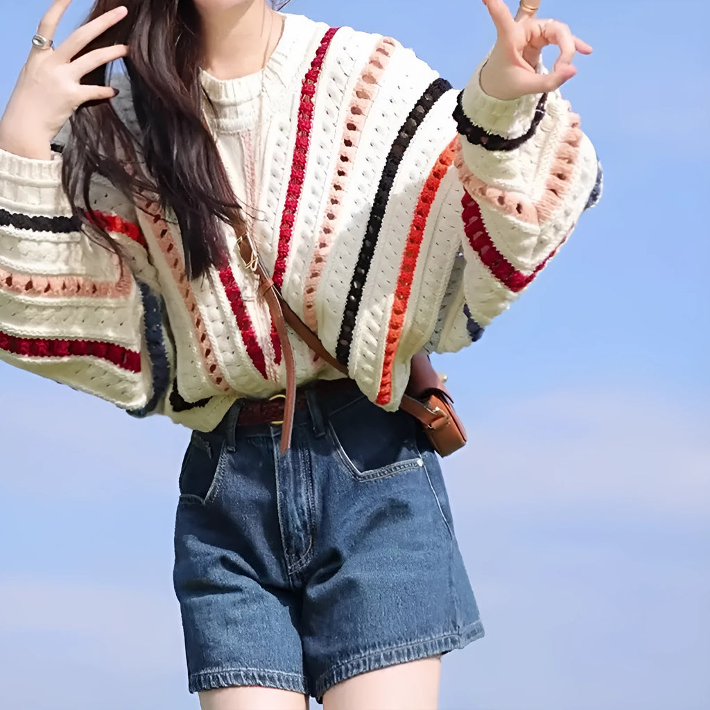 Colourful retro rainbow striped loose sweater with batwing sleeves on a hanger