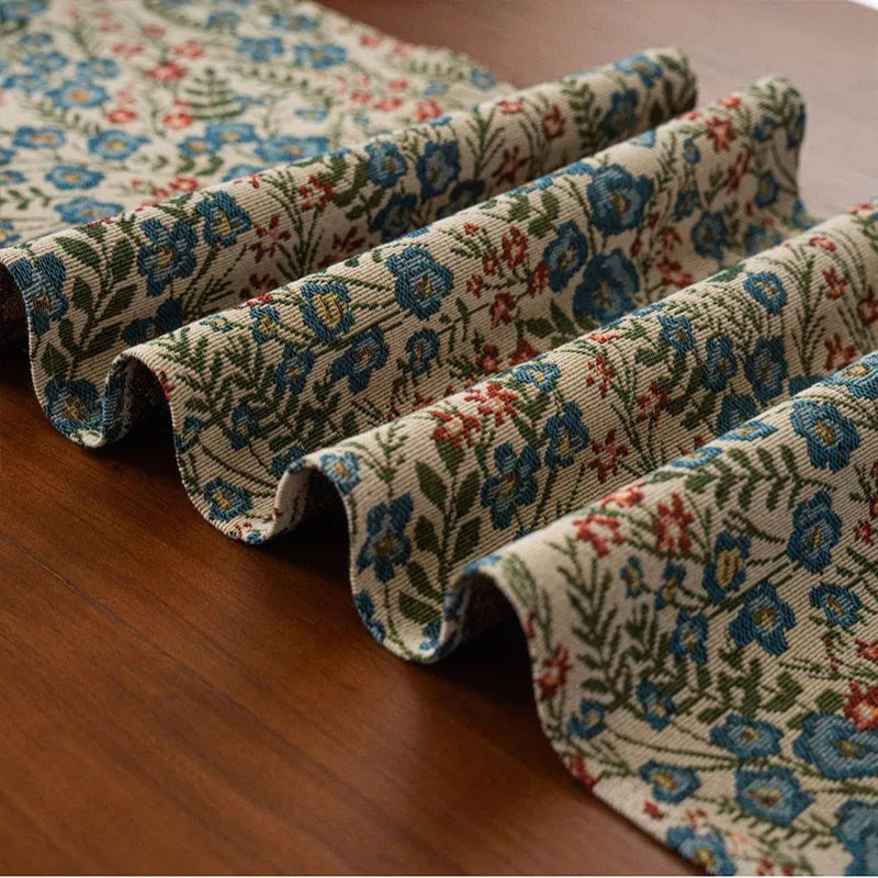 Dark blue striped Nordic jacquard bouquet table runner with tassel trim laid flat on a table.