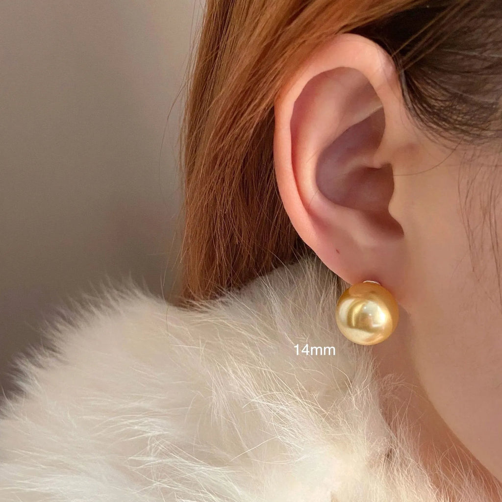 A pair of large geometric pearl stud earrings with a retro eight awn star motif on a silver setting.