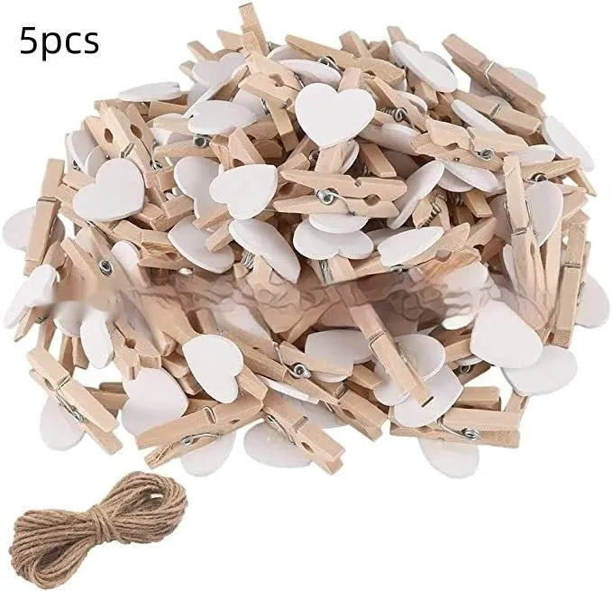 Five small handmade solid wood heart-shaped clips in assorted colours on a white surface.
