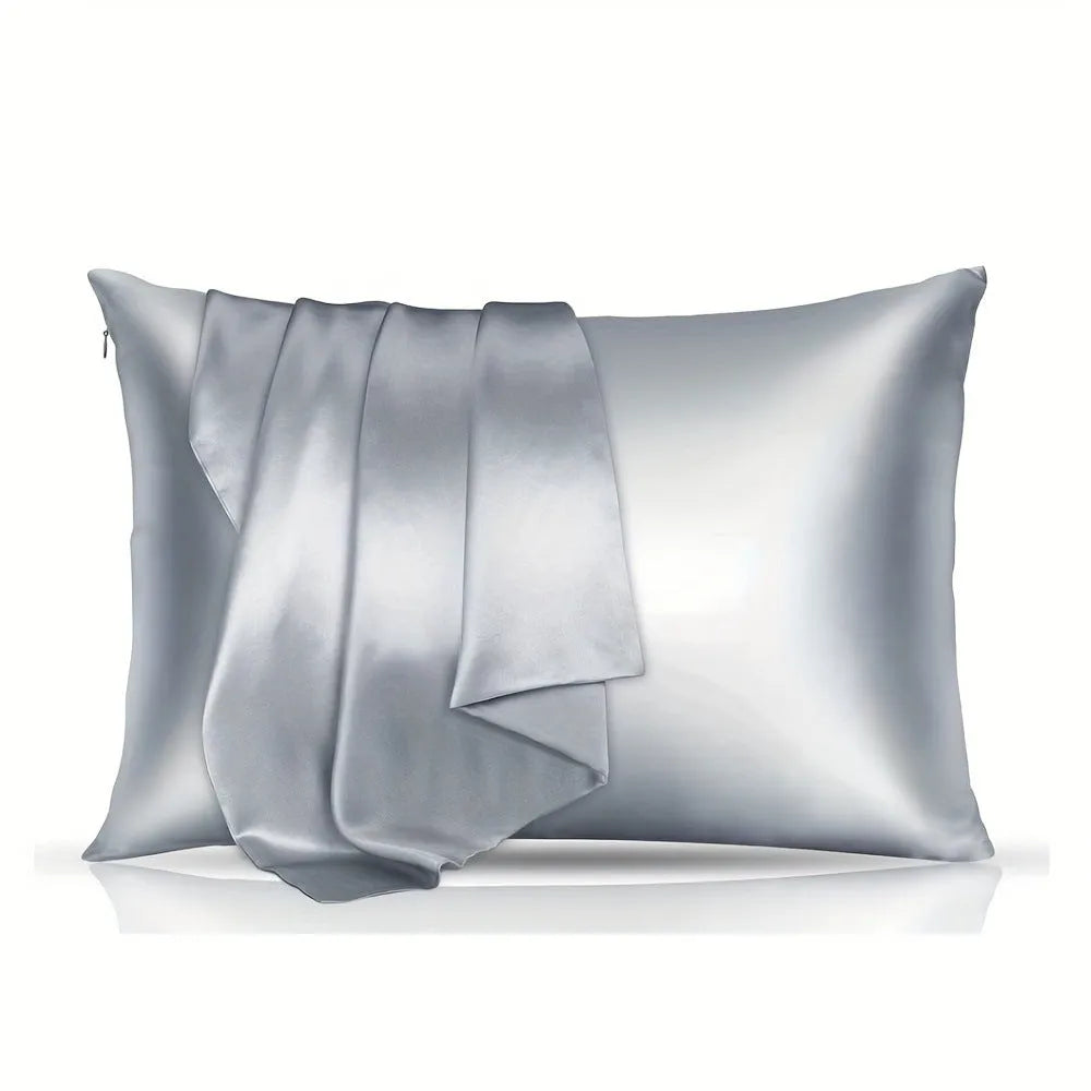 A pair of solid colour satin pillowcases in various colours and sizes on a bed.