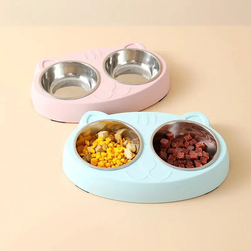 Blue plastic double bowl pet feeding tray for cats and dogs with non-slip rubber feet on a floor.