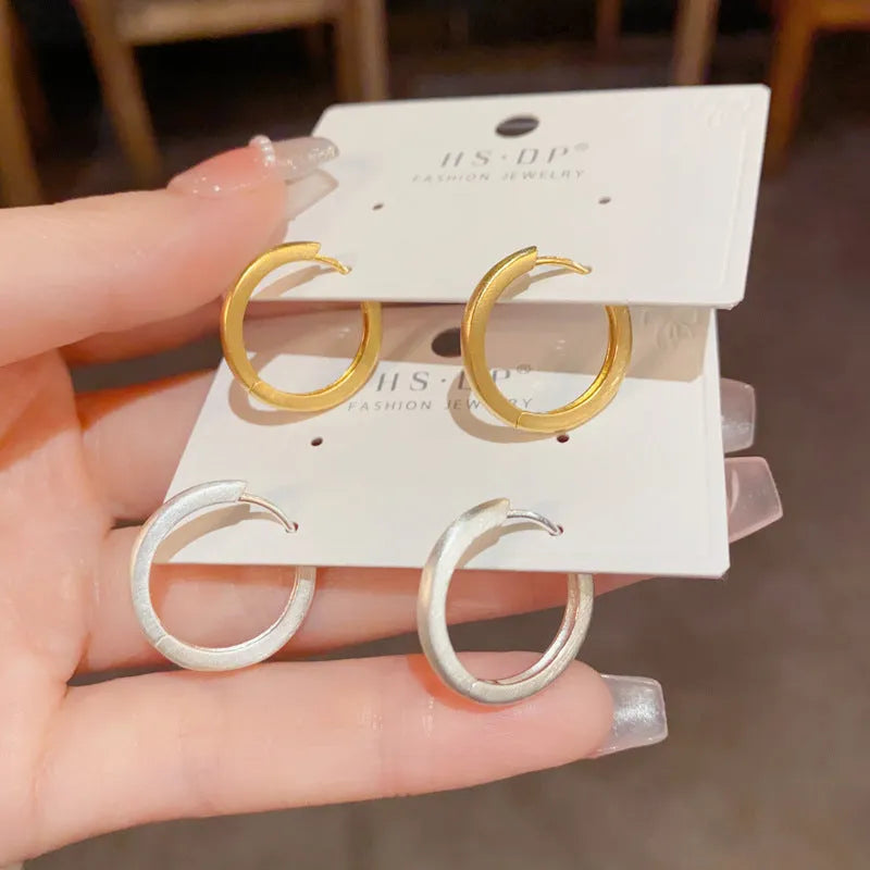 Geometric eyelet ear clips with circular design in gold or silver tone