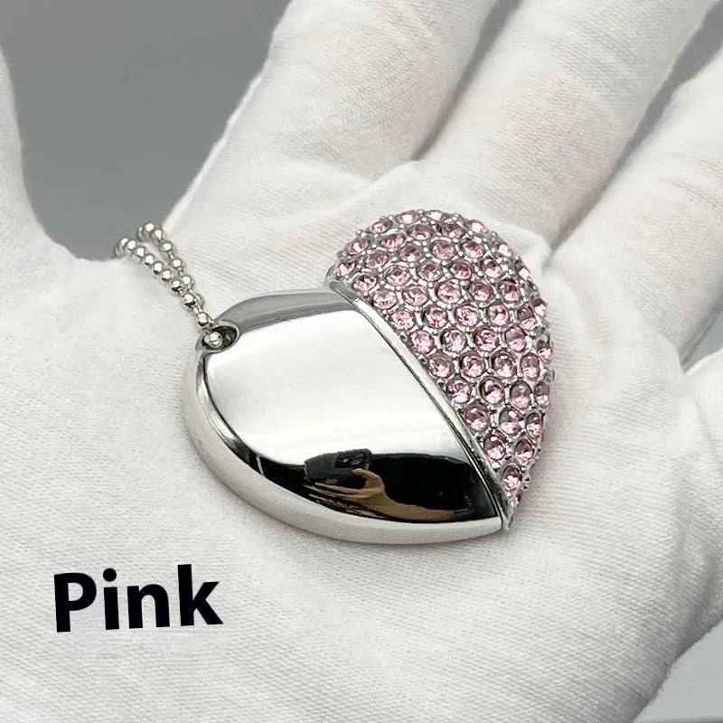 A heart-shaped silver USB flash drive with a brick pattern, shown next to a laptop.