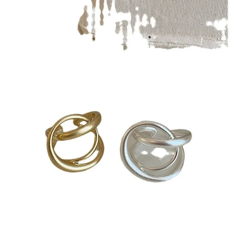 Geometric open ring for women with 3D interlaced matte metal design in gold or silver.