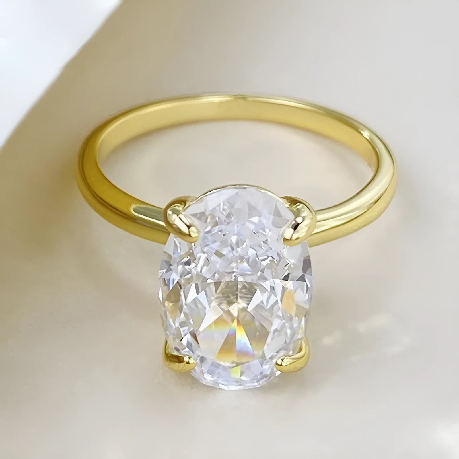 Oval women's ring with four-prong claw setting in gold or silver finish on a 9 silver band.