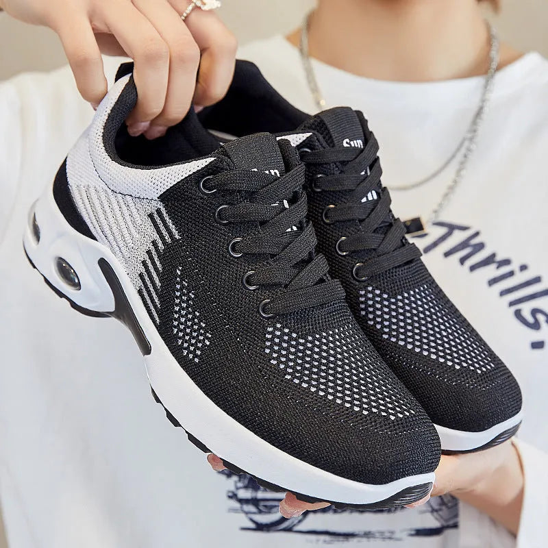 Women's pink Flyknit casual running shoes with mesh lining and flat heel on a white background