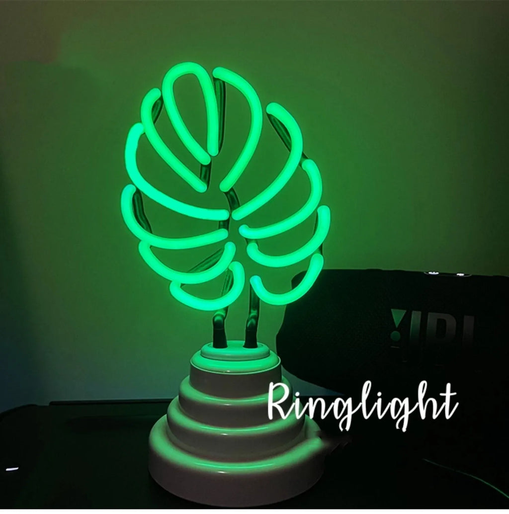 Minimalist white bamboo-shaped desk lamp emitting a soft green LED light, with a black USB cable.