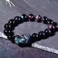 Polished natural ice colour Eye Obsidian crystal beads on an elasticated bracelet cord.