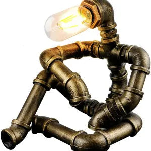Green bronze vintage industrial robot desk lamp with iron pipe design on a wooden table.