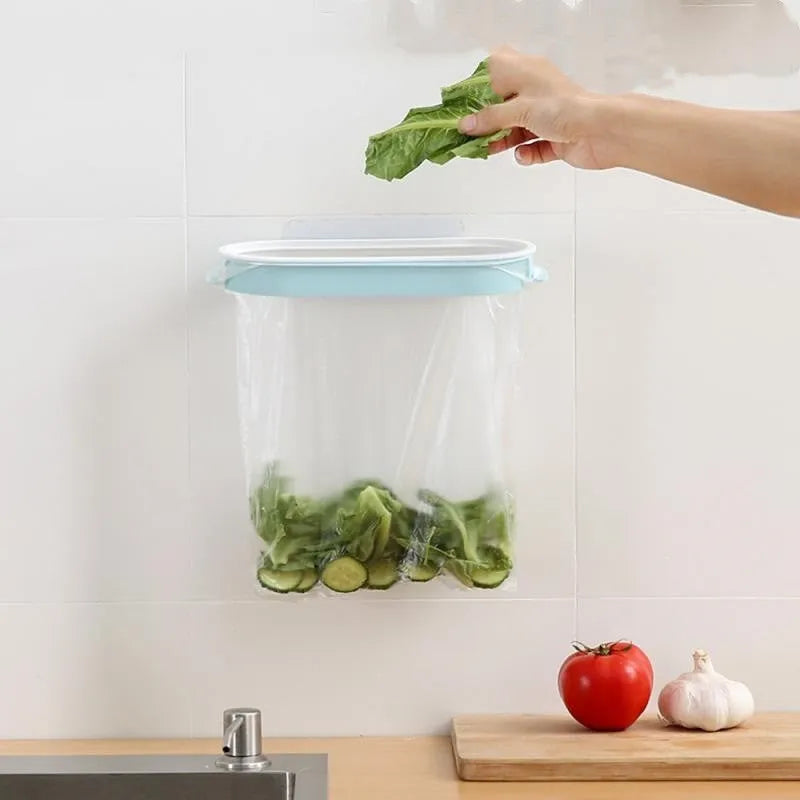 Blue plastic kitchen bin bag storage rack mounted on a cabinet door holding a roll of bags.