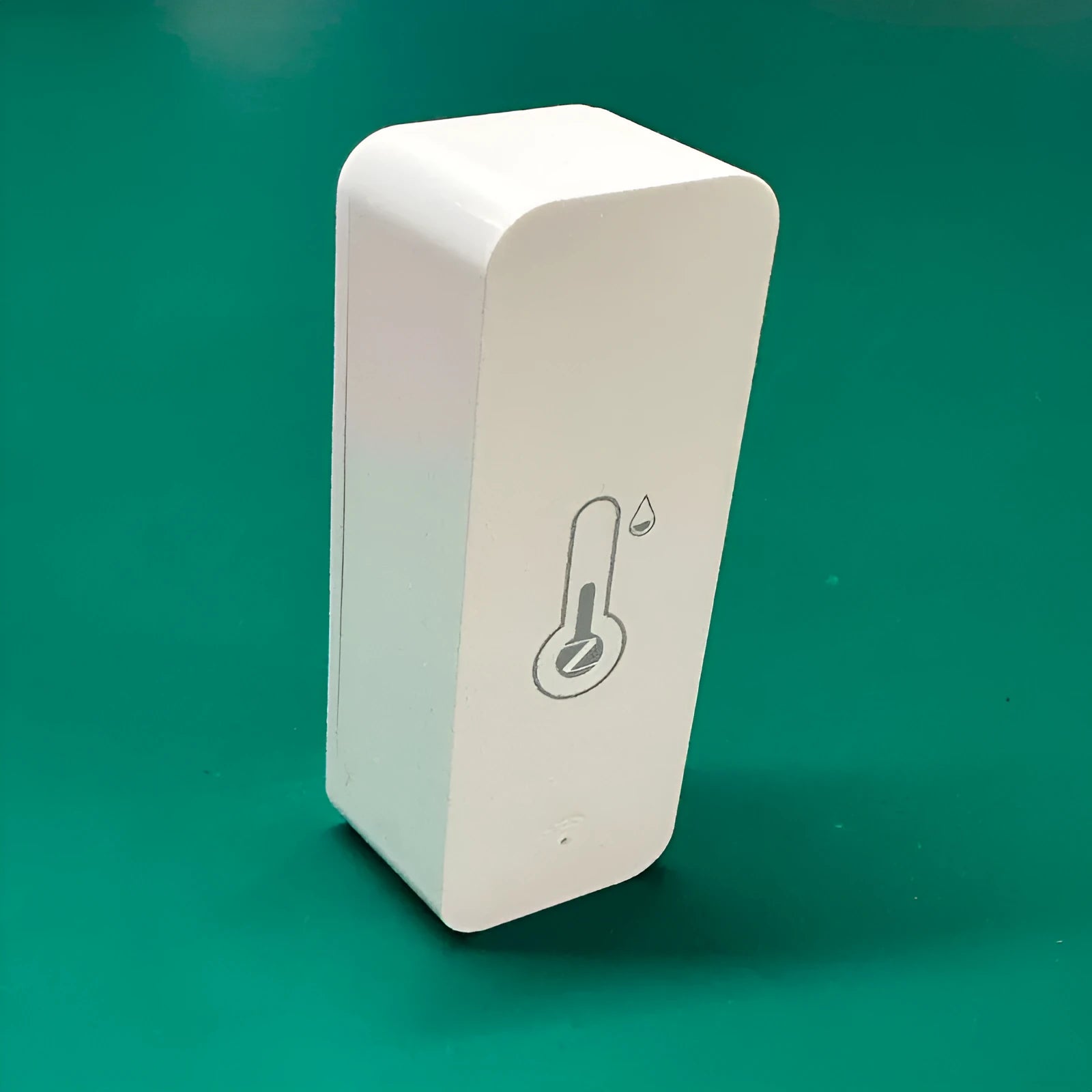 White WiFi and Zigbee smart temperature and humidity sensor on a table