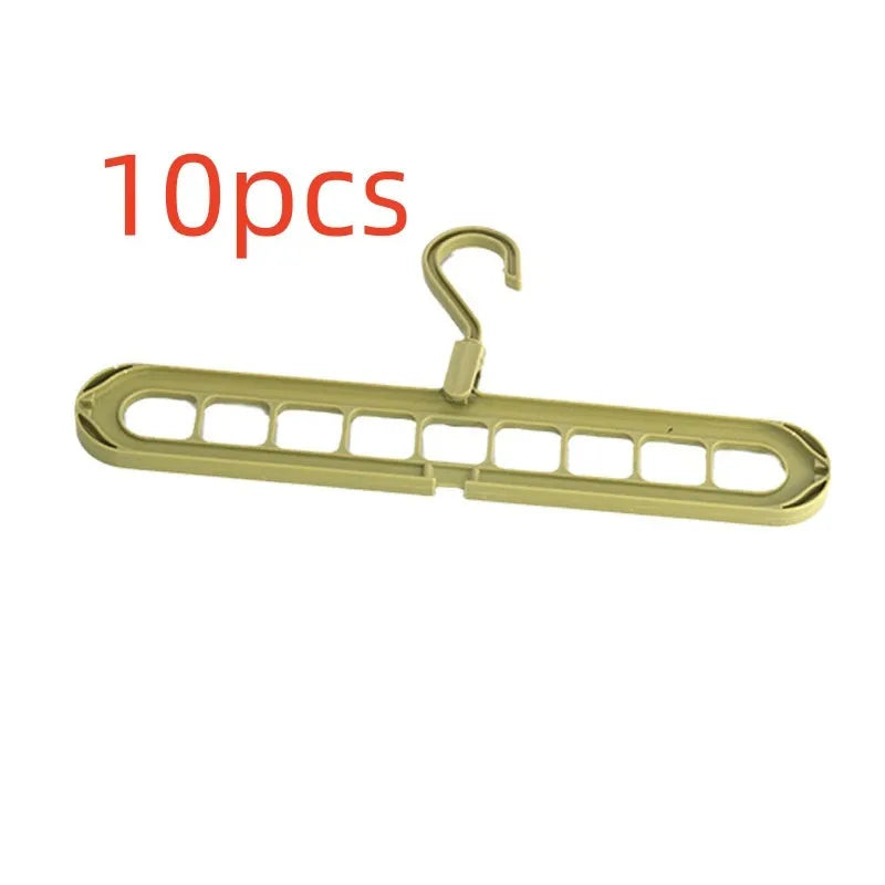 Green plastic multifunctional hanger with nine arms for folding trousers, shown hanging on a rail.