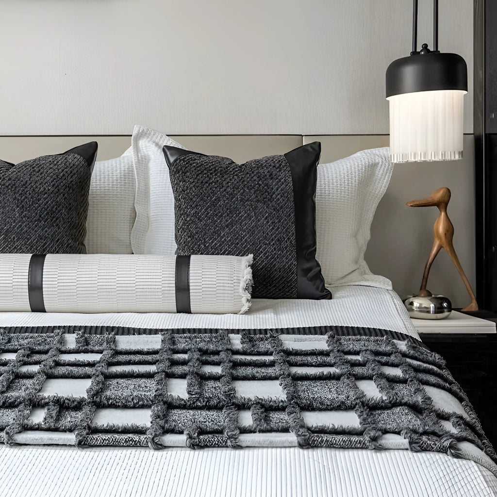 Grey and white plaid polyester bed runner blanket with matching pillowcase and leather round pillow on a double bed.