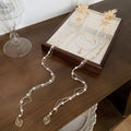 Gold-coloured women's acrylic hairpin with pearl, diamond and long tassel decoration.