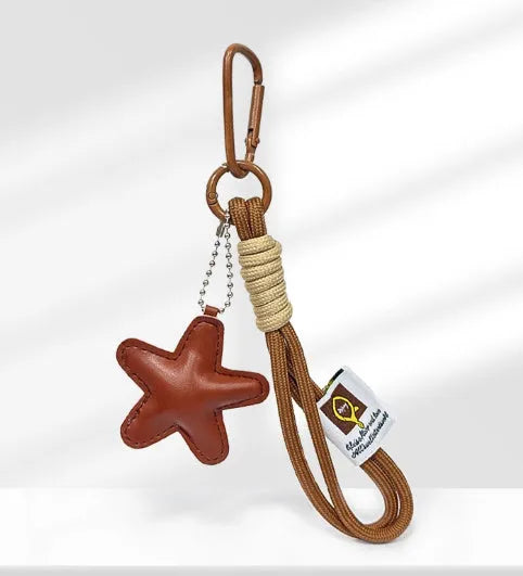 Handmade brown star resin handbag pendant with cartoon soda bread design on a brown strap