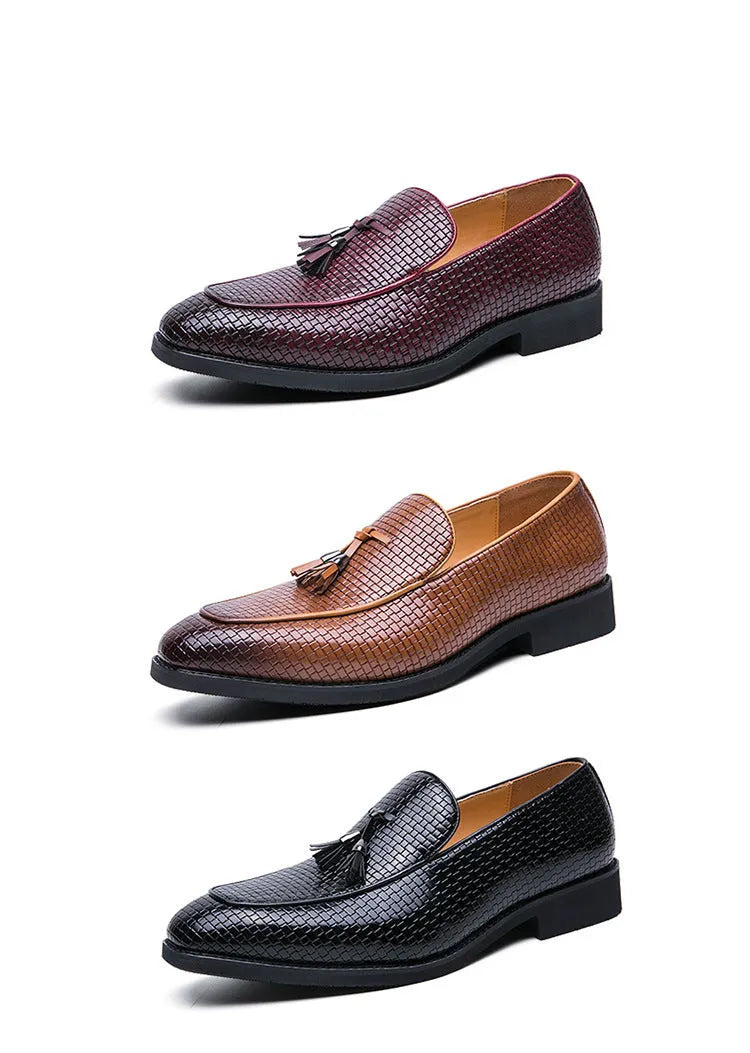 Men's black pointed toe slip on loafers with a tassel detail on the front, shown on a plain background.