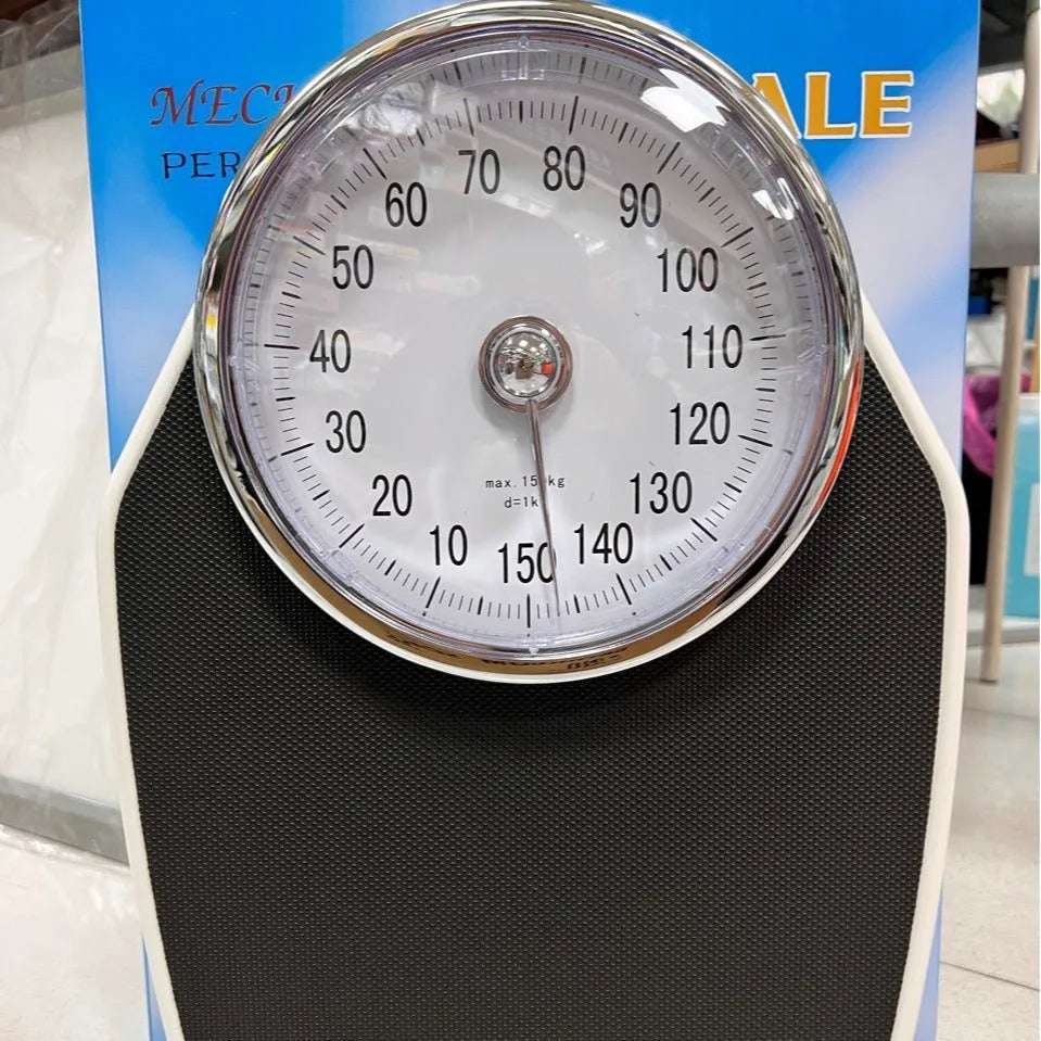 Black mechanical bathroom scales with large analogue dial showing weight measurements