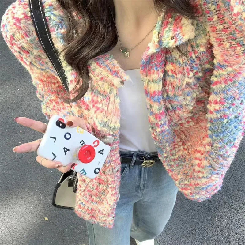 Pink and green retro style slim-fit knitted cardigan sweater on a hanger.