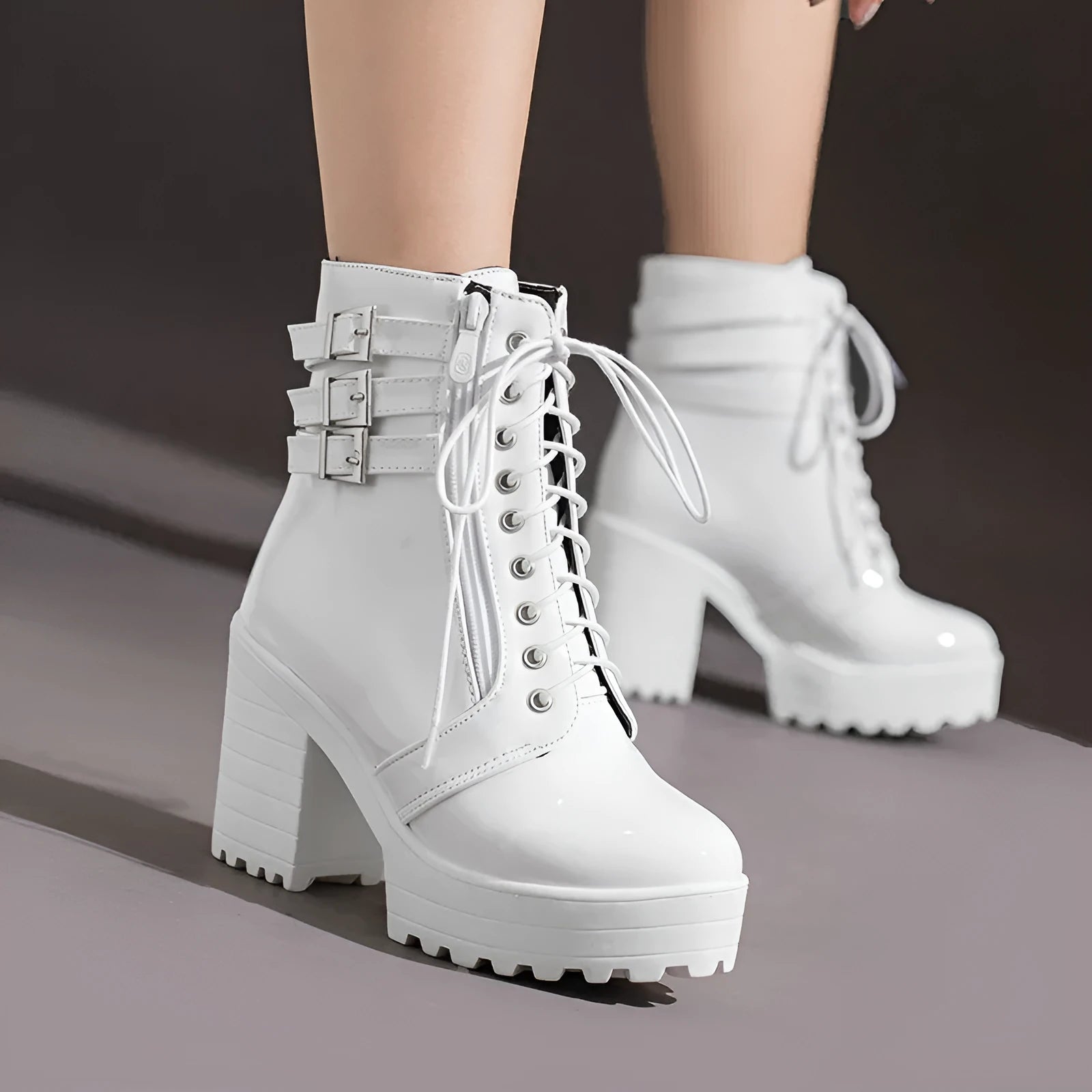 Women's black thick-heeled lace-up ankle boots with a round toe and rubber sole on a waterproof platform.
