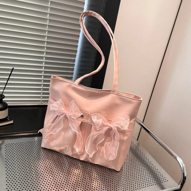 Black college-style bow tote bag with double shoulder straps and zippered compartment