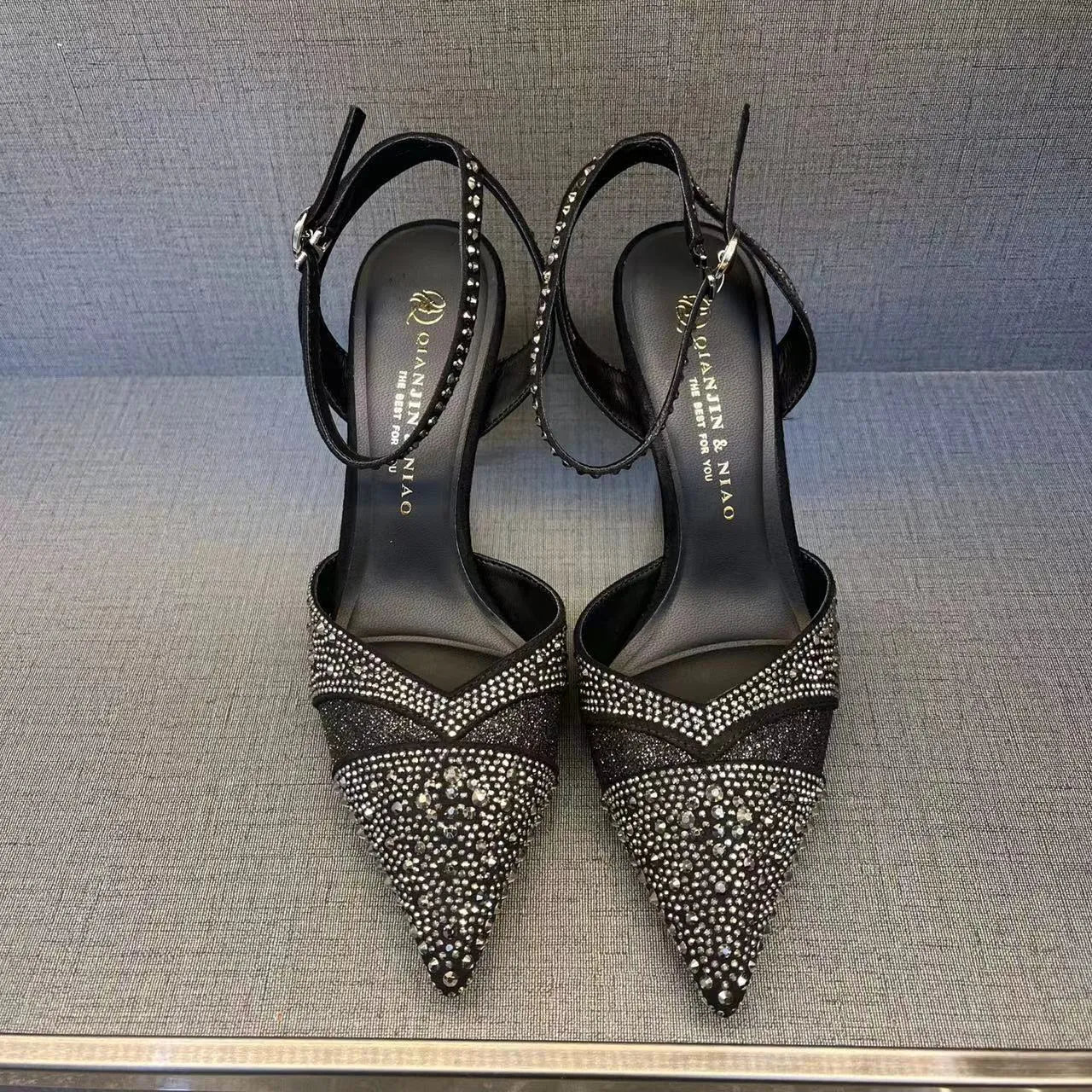 Women's black and silver hollow high heels with red stiletto soles and pointed toes.