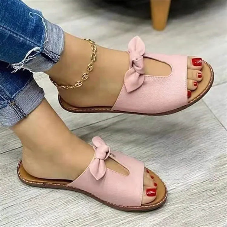 Ladies casual sandals with bow decoration and fish mouth toe opening in black, pink, and gold colours.