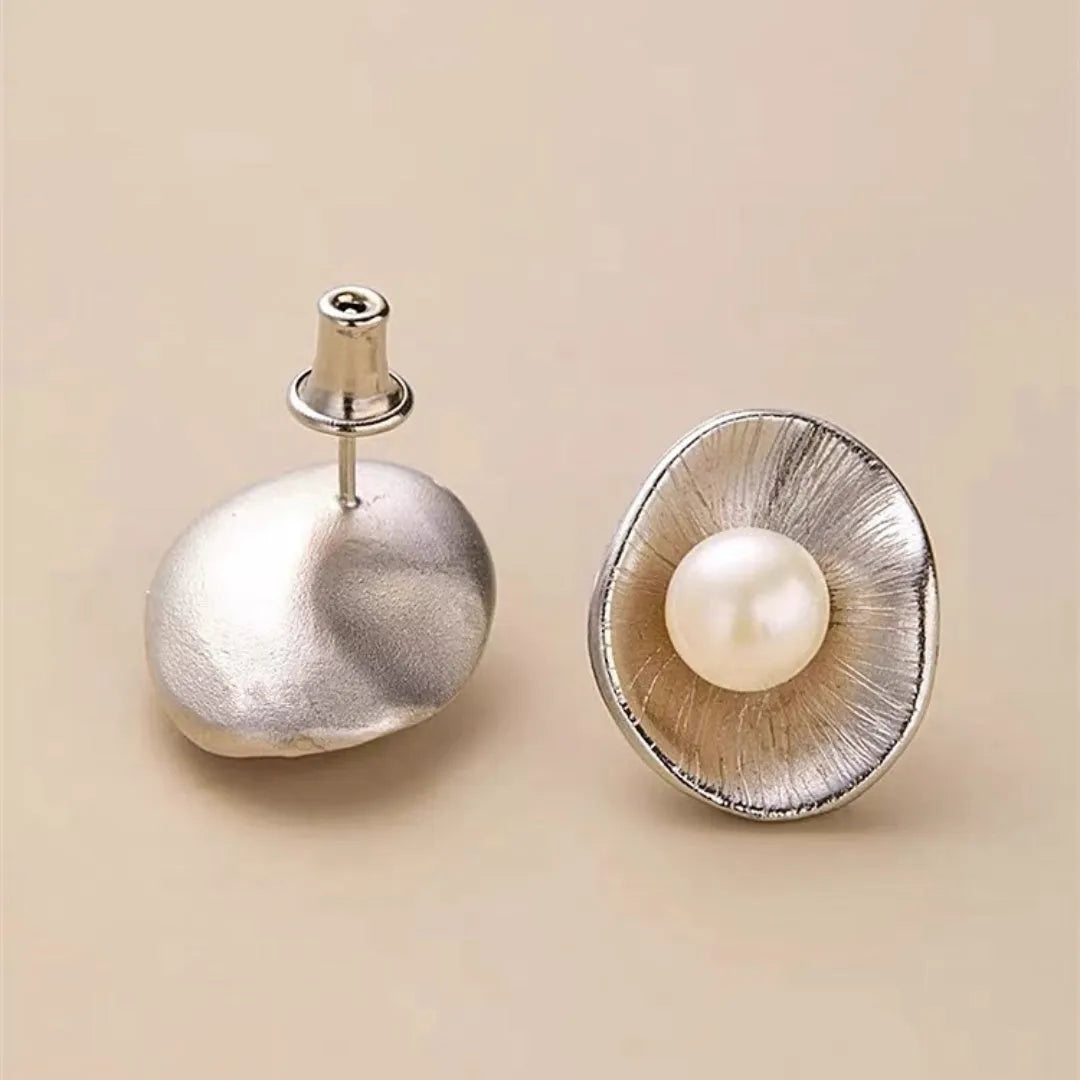 A pair of gold-coloured geometric sterling silver stud earrings featuring a single pearl.