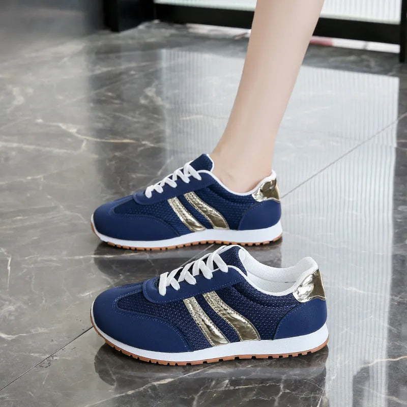 Blue women's lace-up tennis shoes with cross shoulder straps and a flat rubber sole.