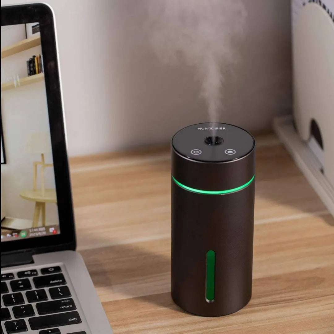 Black aluminium car humidifier and essential oil diffuser with colourful night light on, 66mm wide.