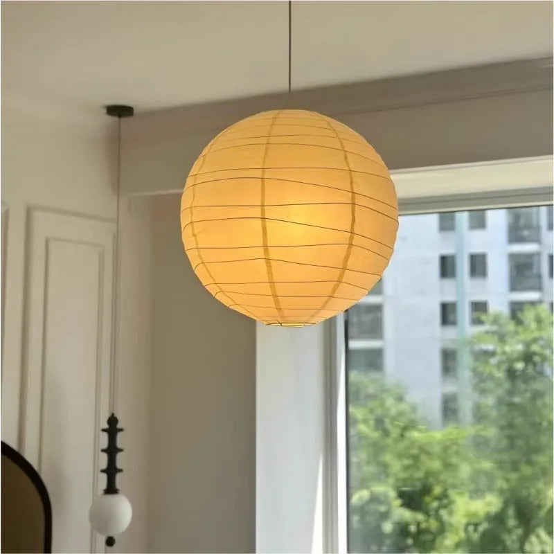 Japanese style white rice paper pendant chandelier with a woven frame, shown in a room setting.