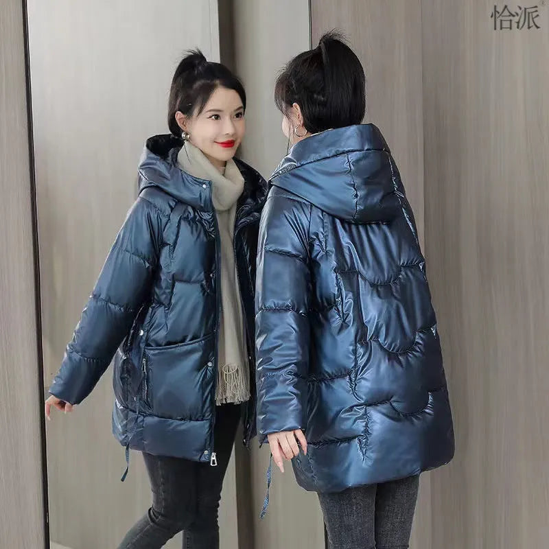 A woman wears a loose-fitting green hooded winter jacket with long sleeves.