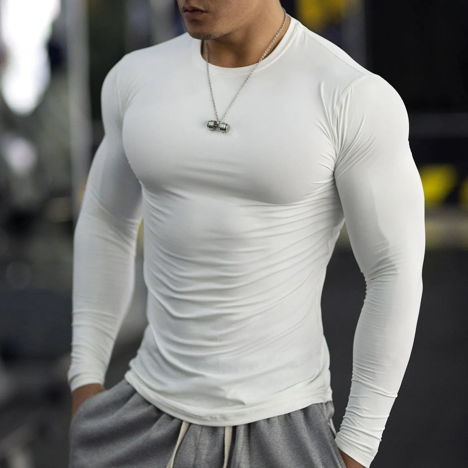 Man wearing black long-sleeved slim-fit fitness tights for gym workout or running.