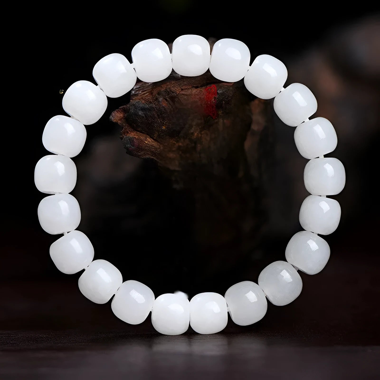 White Hetian jade barrel bead bracelet on a wrist, showing unisex casual style.