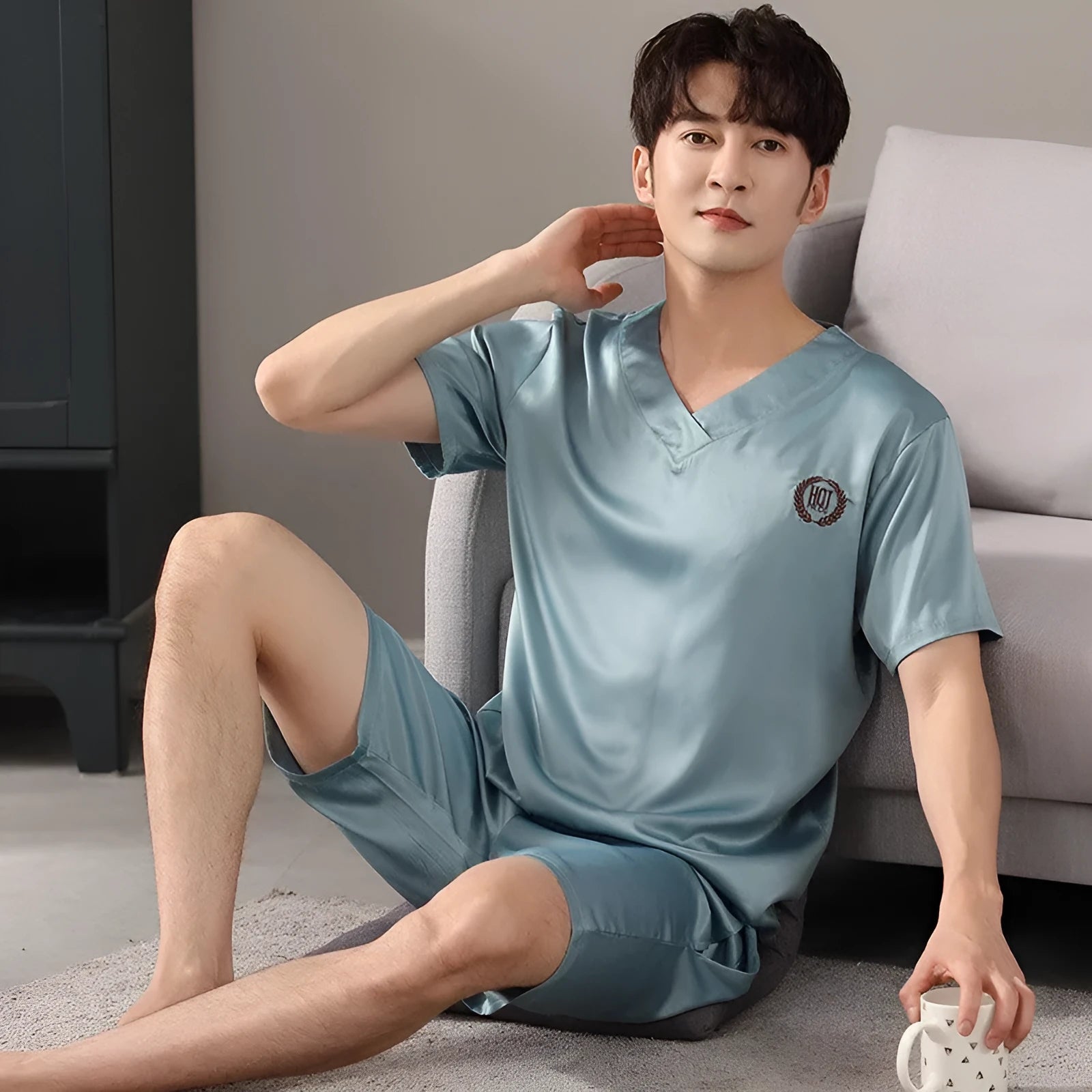 Man's light blue ice silk pyjama set with short sleeves and loose shorts laid flat.