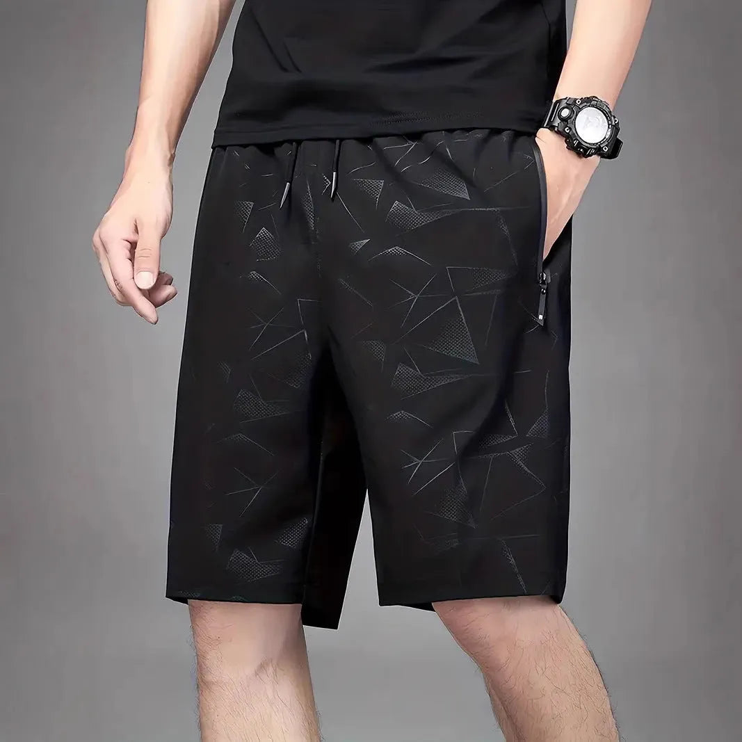 Man wearing loose grey polyester sports shorts with an elastic waistband.