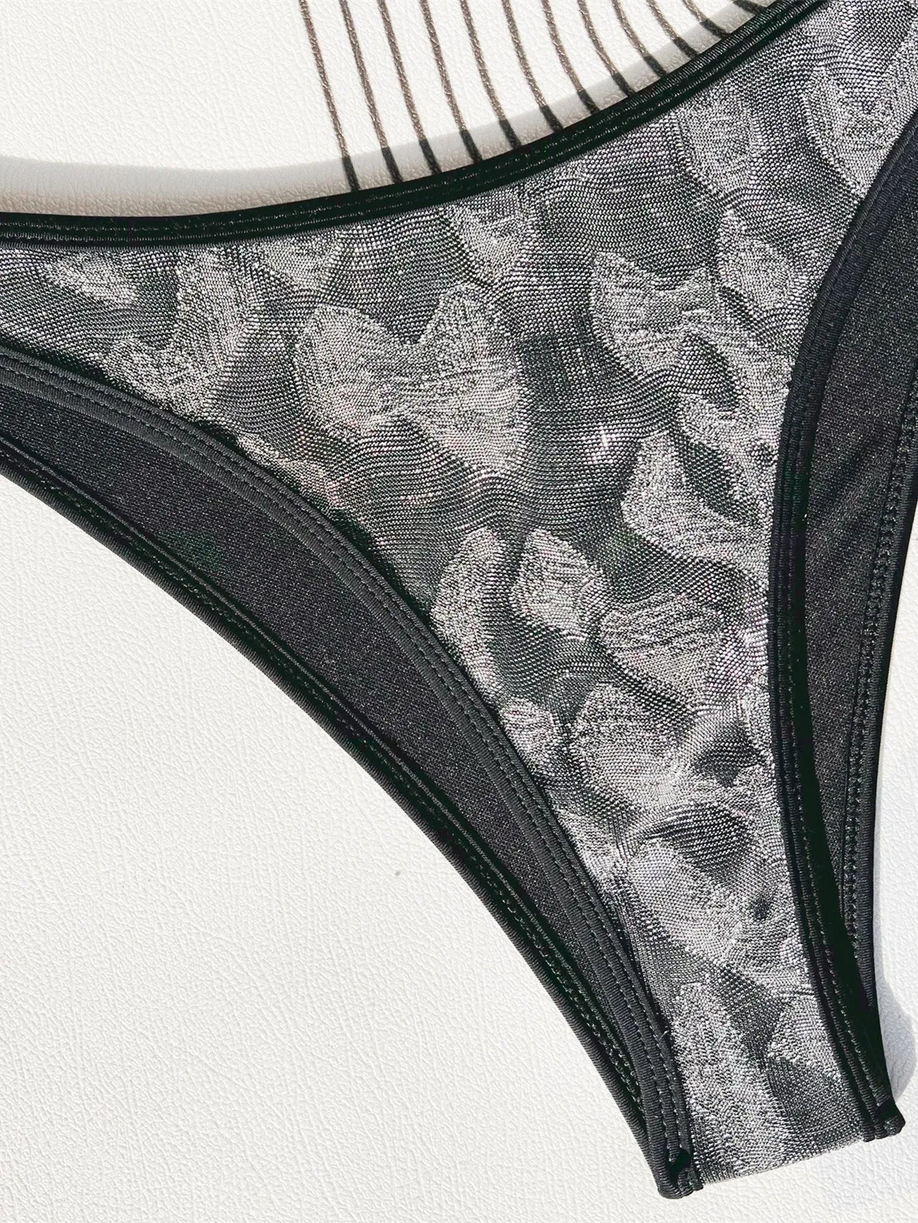 Black ladies bikini strap swimsuit made from polyester fabric, showing front and back views.