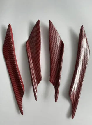 Set of four black ABS plastic bumper blade spoilers for car modification on a white background.