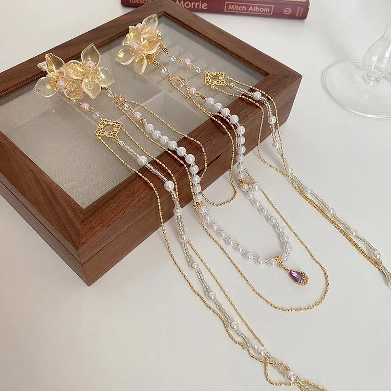 Gold-coloured women's acrylic hairpin with pearl, diamond and long tassel decoration.