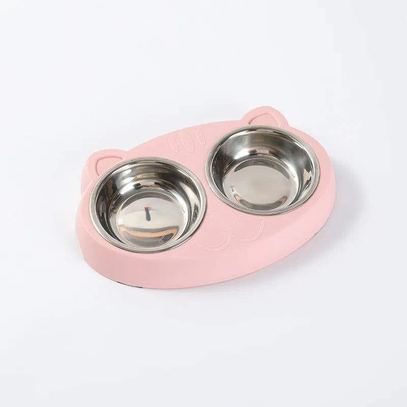 Blue plastic double bowl pet feeding tray for cats and dogs with non-slip rubber feet on a floor.