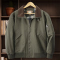 Men's washed cotton baseball flight jacket in beige, shown on a hanger.