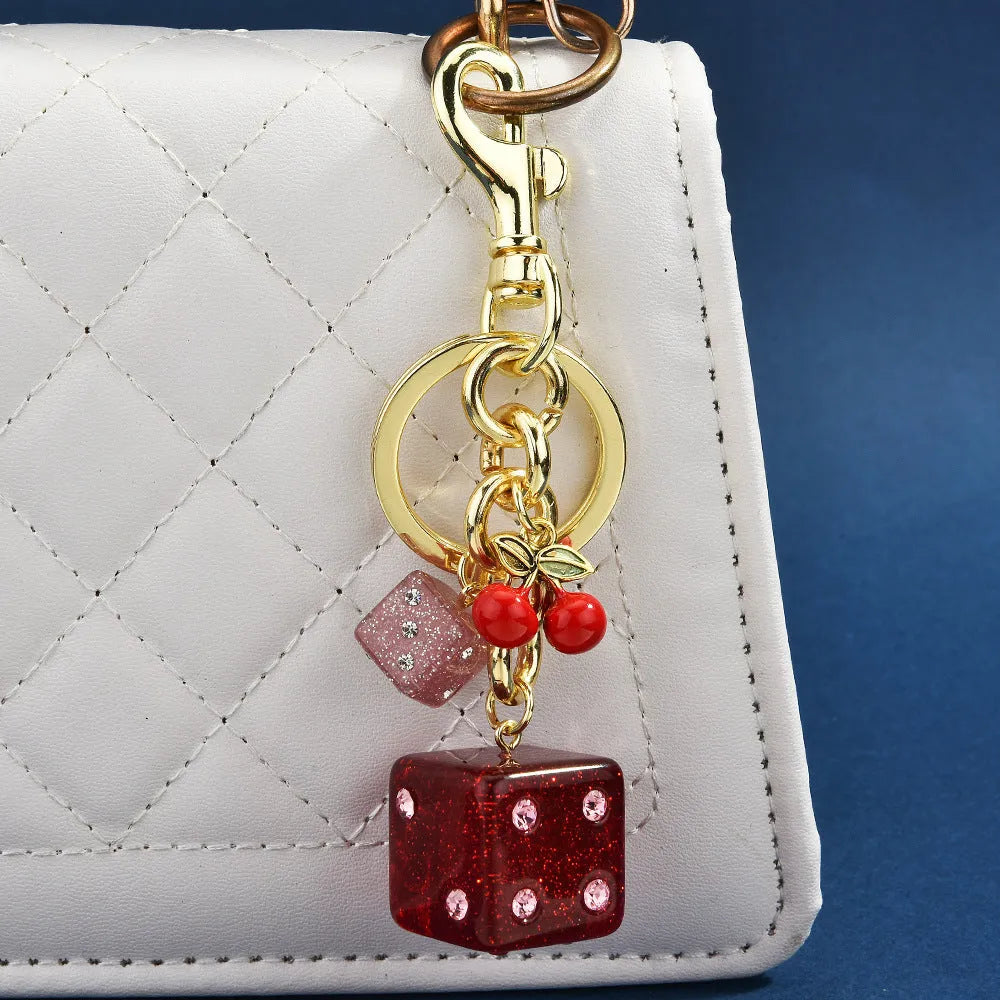 Vintage cherry two-tone dice design on a square electroplated metal keychain pendant.