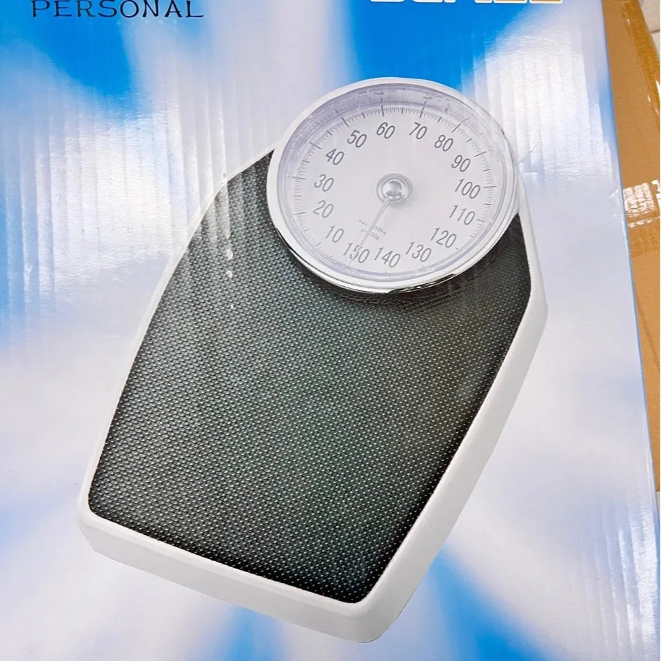 Black mechanical bathroom scales with large analogue dial showing weight measurements