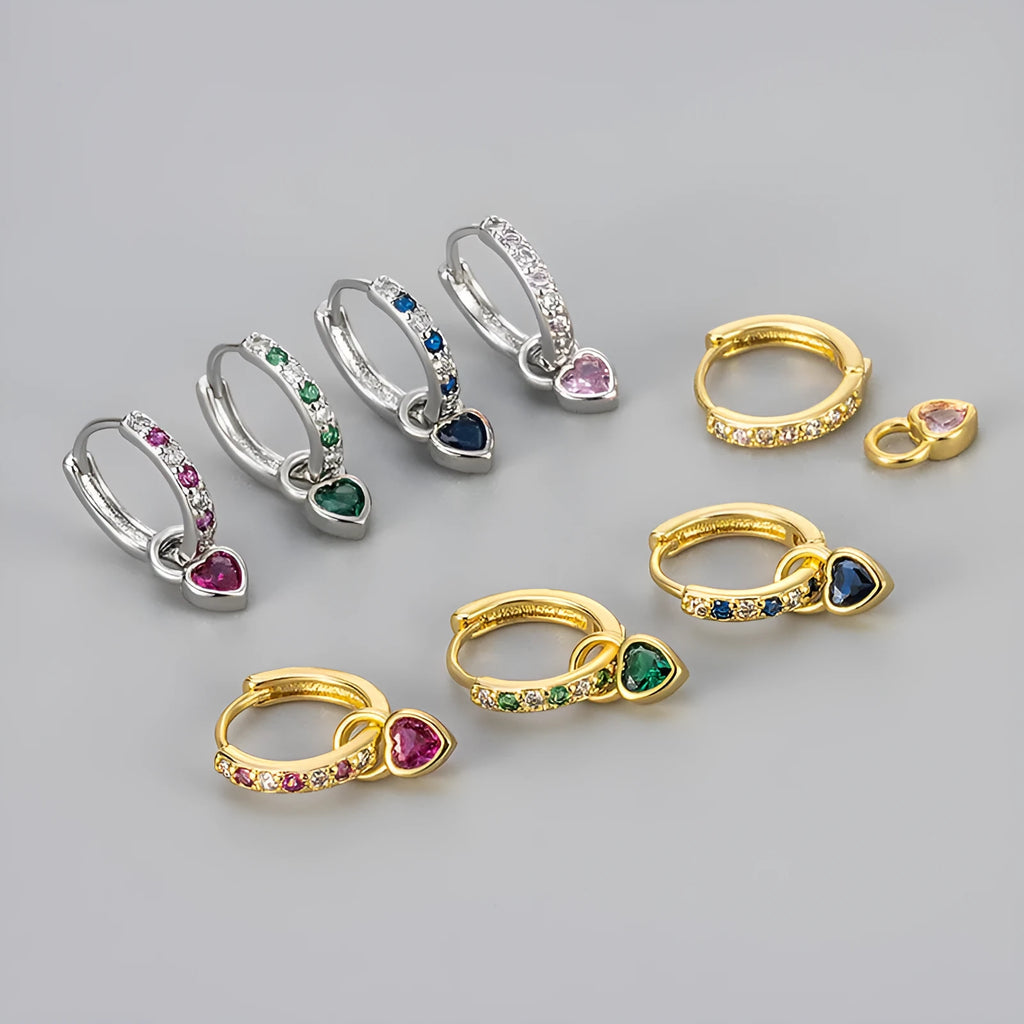 Women's fashion earrings with heart-shaped drops containing coloured gemstones in gold or white gold colour settings