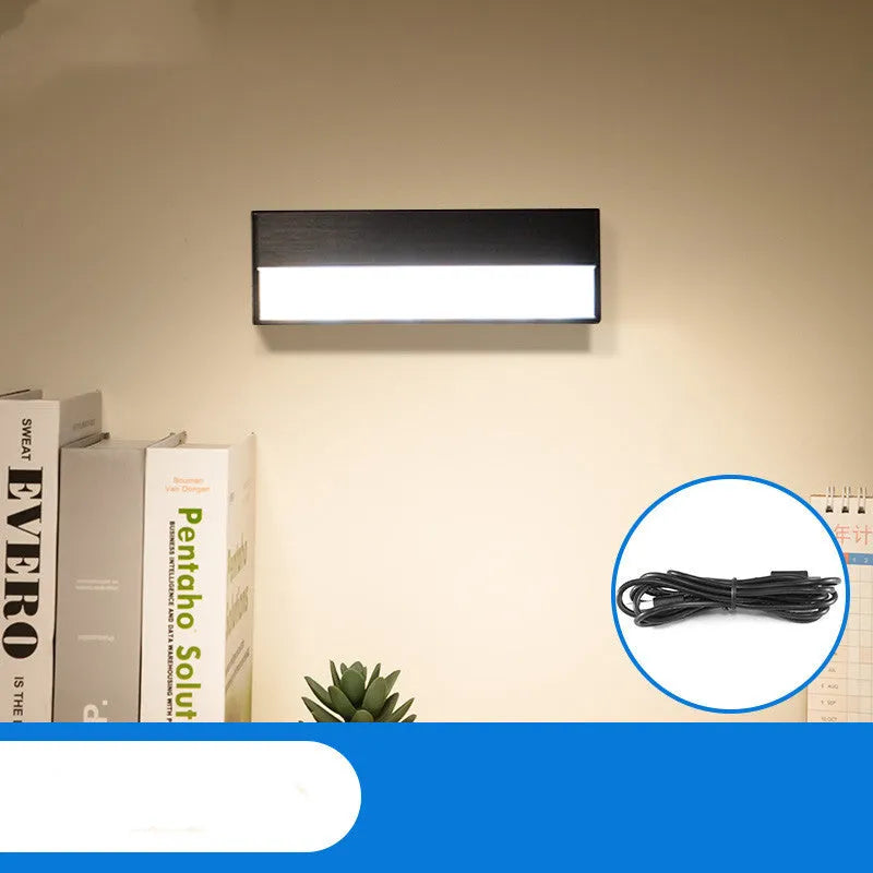 Compact white magnetic table lamp with a large luminous surface and USB charging port.