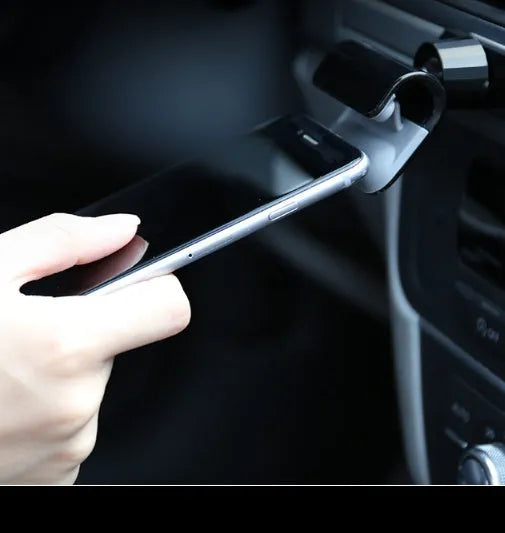 Black gravity car phone holder with 360-degree rotating head mounted on a car air vent.