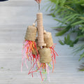Colourful shredded paper parrot toy made of wood and sisal rope, measuring 35cm long.