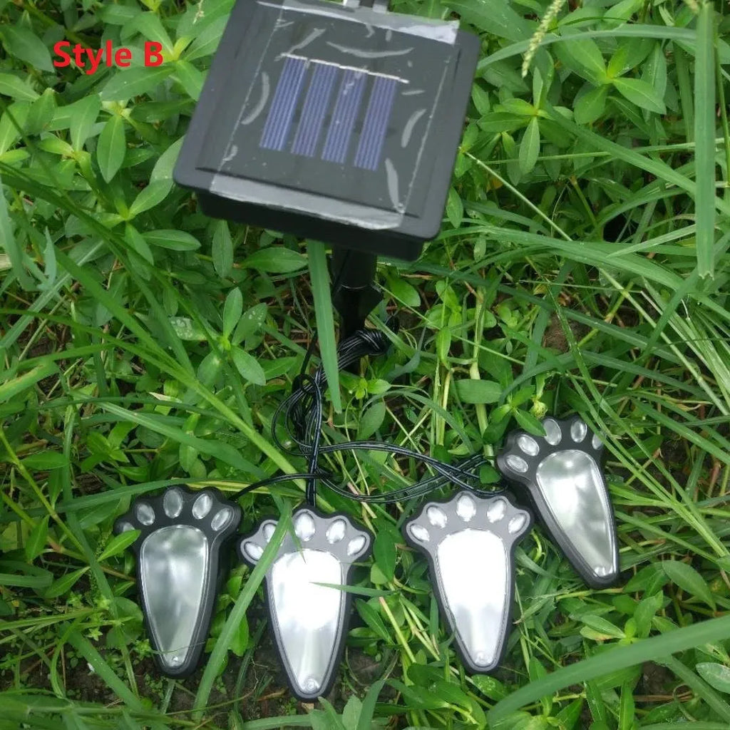 Black solar powered bear paw print garden lights set with four lights and solar panel