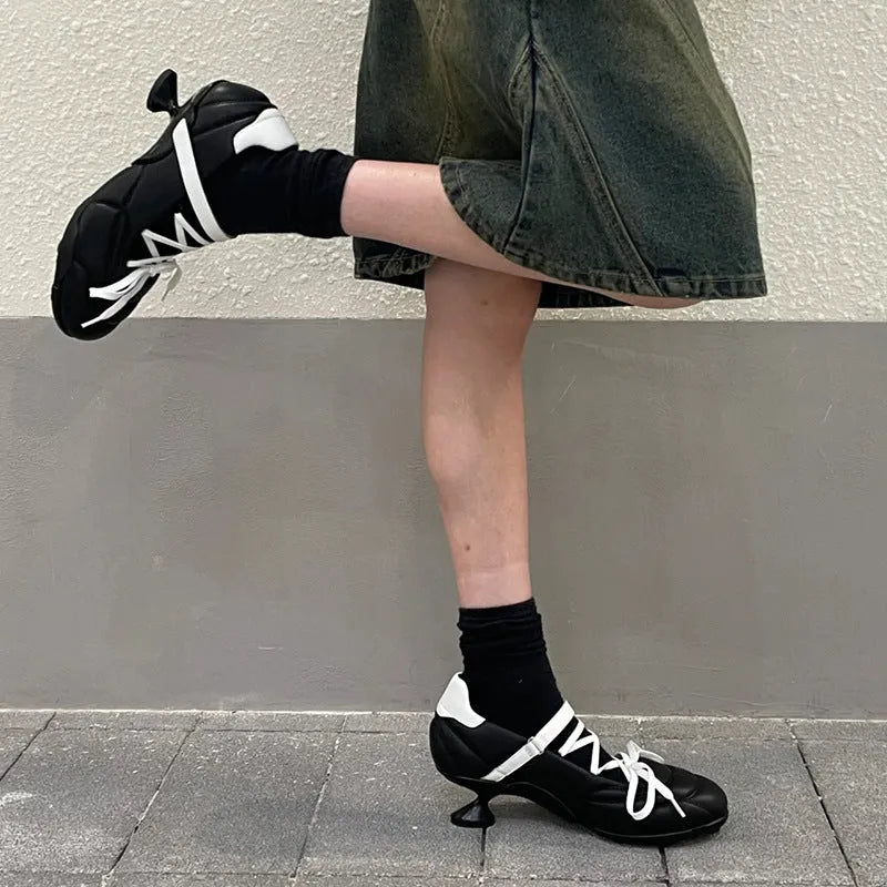 Women's silver lace-up sports shoes with a decorative bow and platform sole, showing round toe and low-top design.